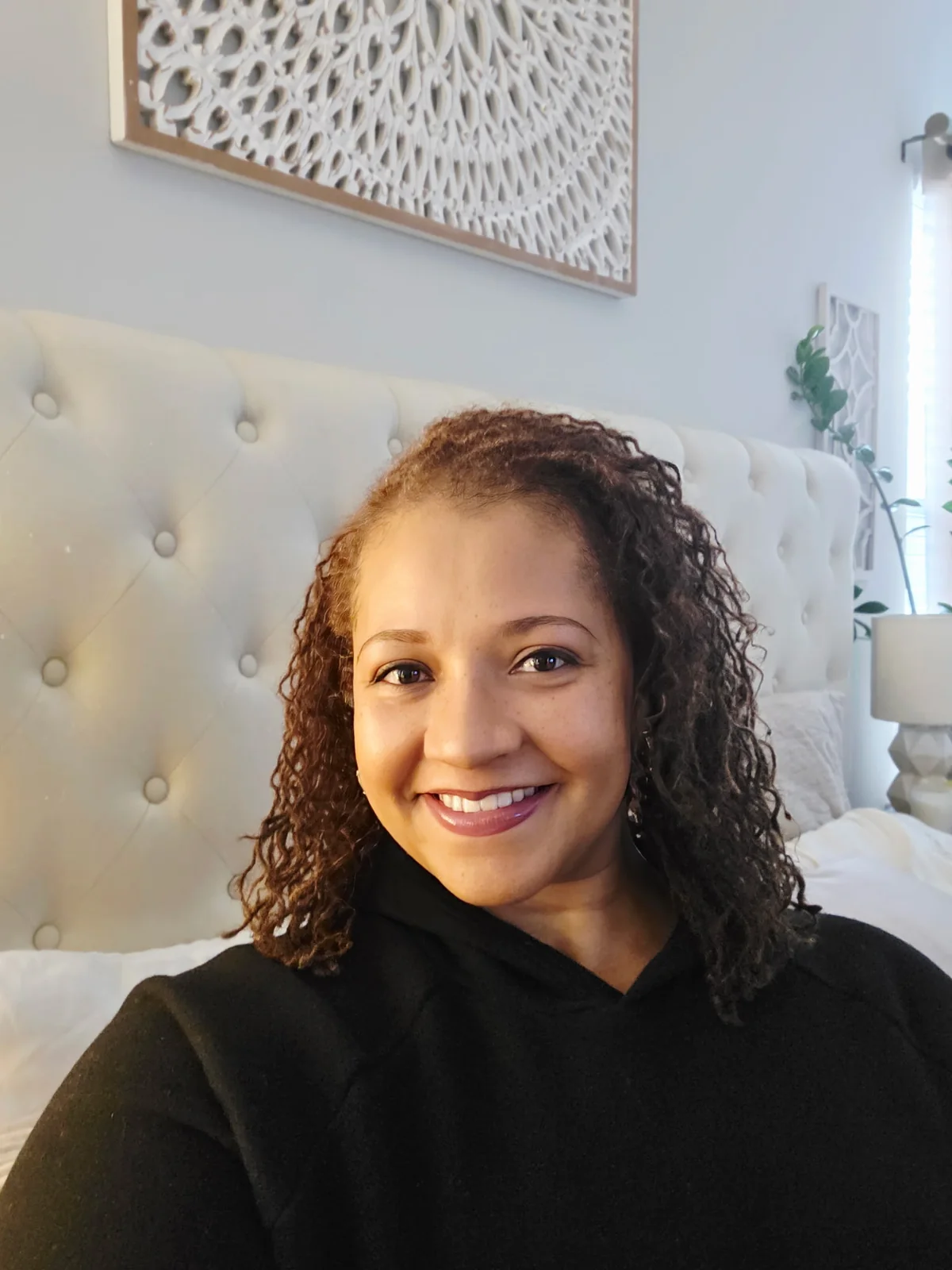 Atoya Jones, founder and creator of BFabulus, smiling in a calm bedroom setting.
