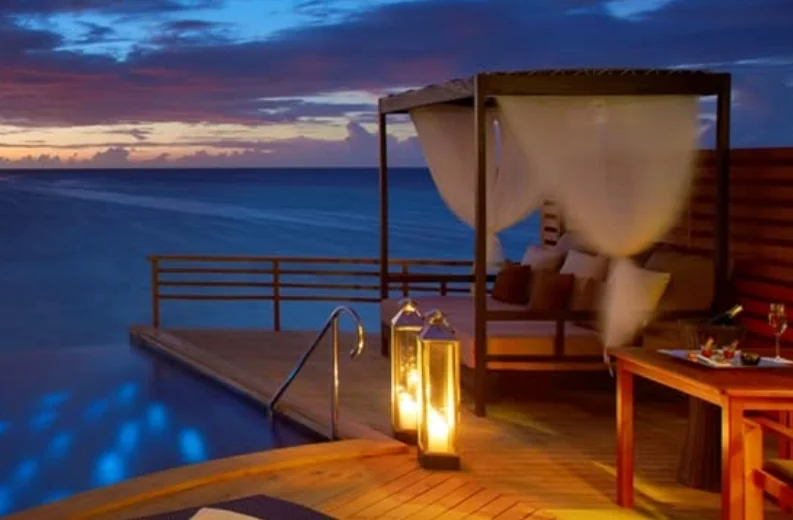 Ocean retreat cabana with warm lanterns and soft evening light.